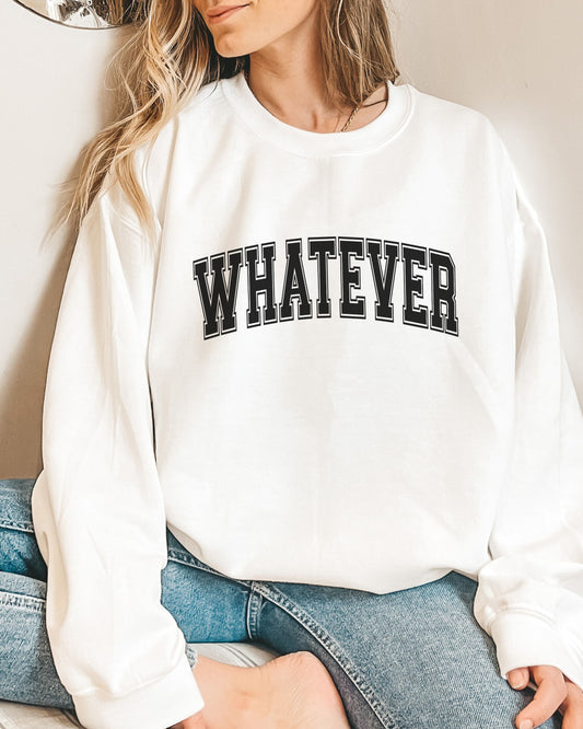 Person wearing a white sweatshirt with 'WHATEVER' text, sitting on a couch.