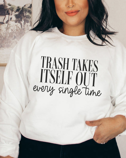 Person wearing a white sweatshirt with text 'TRASH TAKES ITSELF OUT every single time'.
