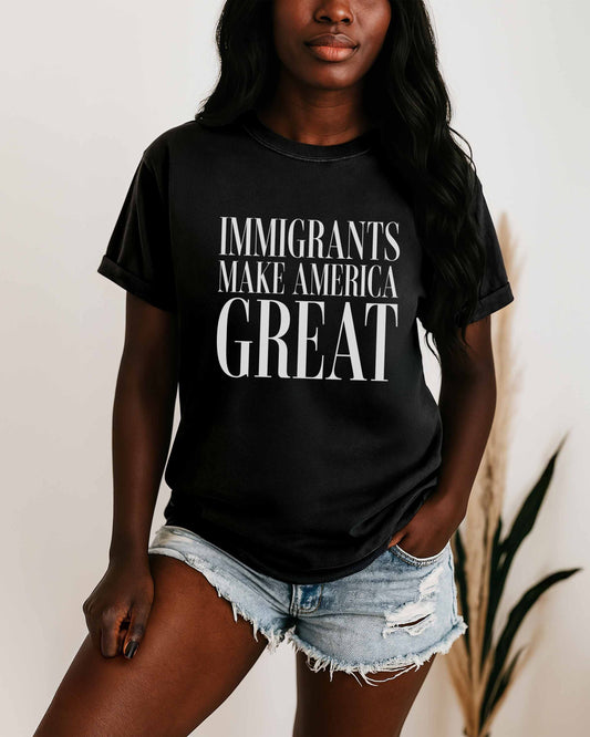 Person wearing a black t-shirt with 'IMMIGRANTS MAKE AMERICA GREAT' text.