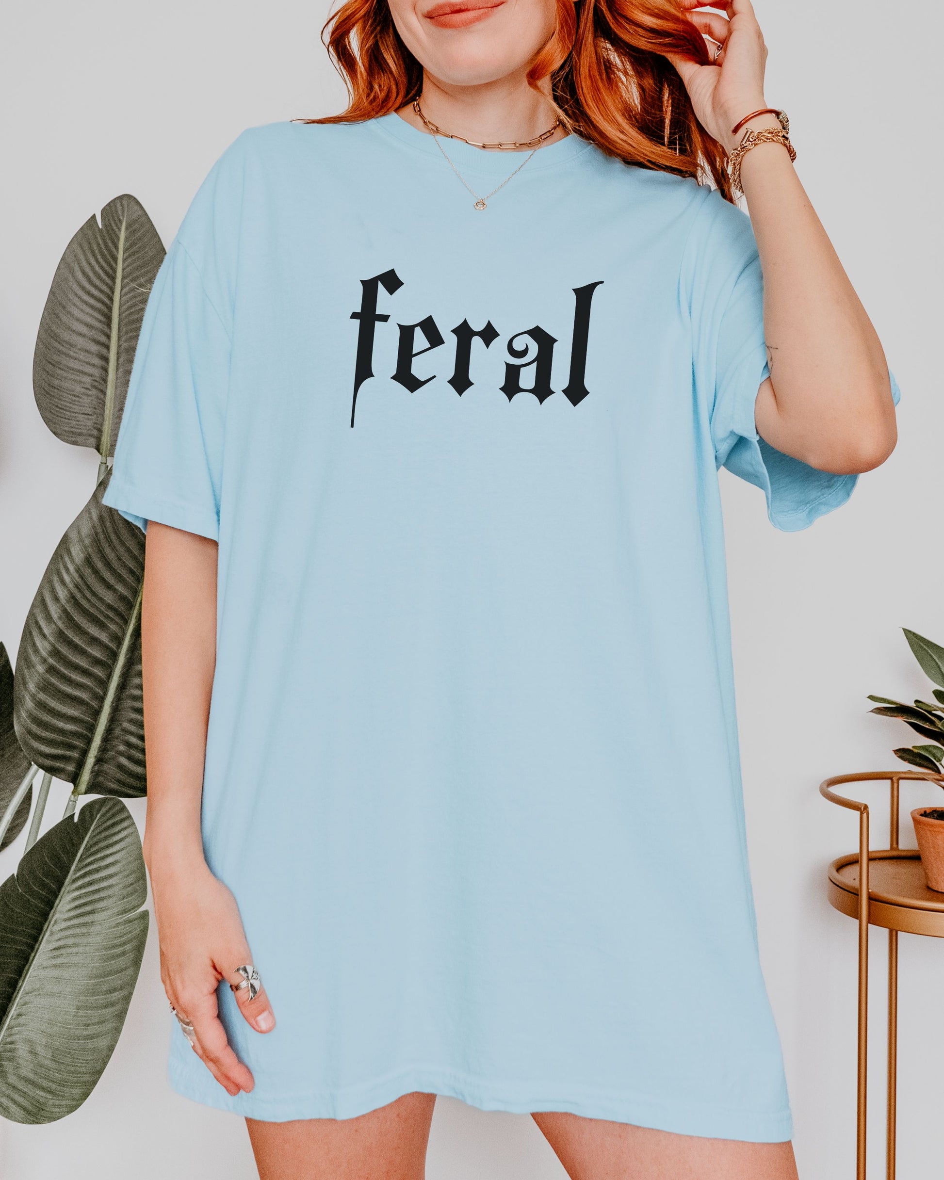 grunge aesthetic feral t-shirt in black font worn by model, in color chambray