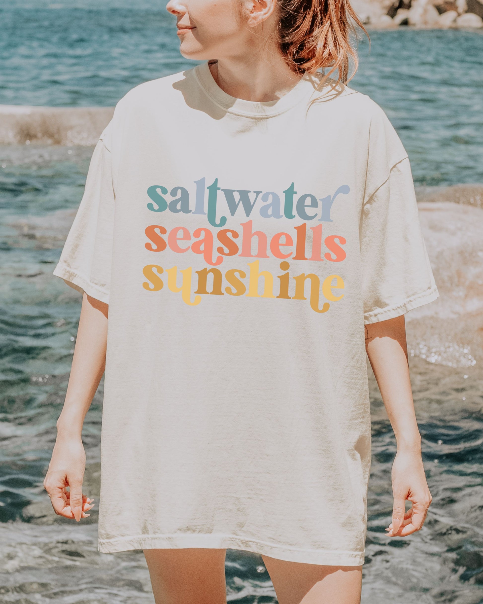 woman wearing beach vibes shirt with saltwater seashells sunshine design
