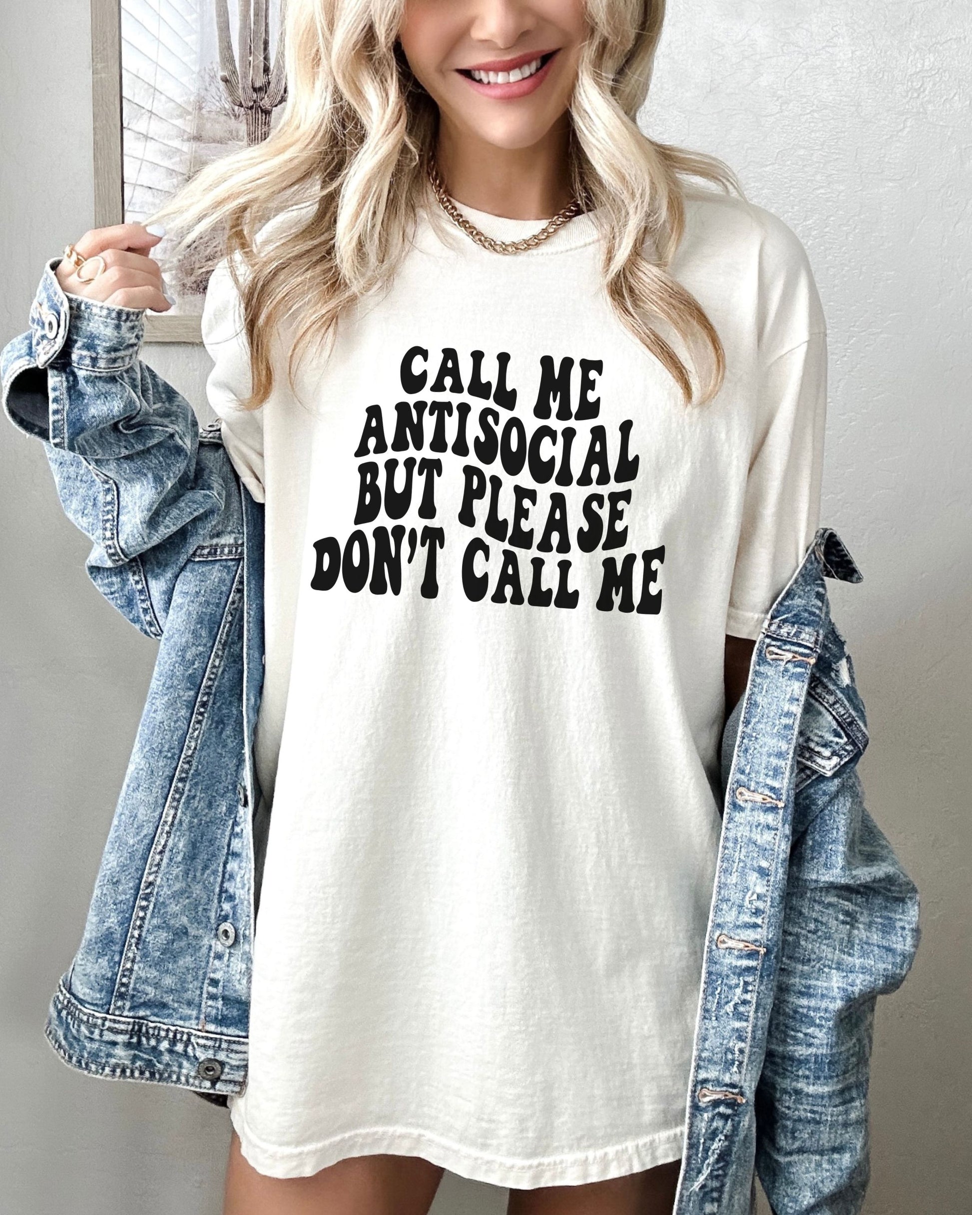 Person wearing a white t-shirt with text and a denim jacket.