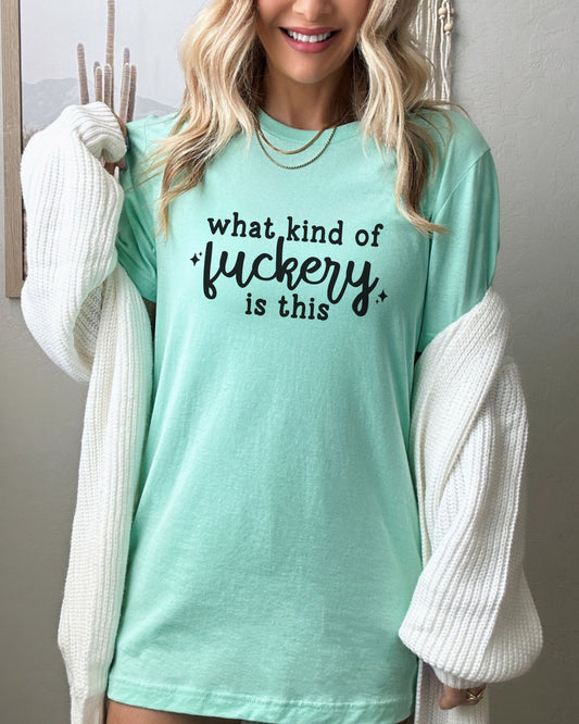 Person wearing a light blue t-shirt with text, standing against a neutral background
